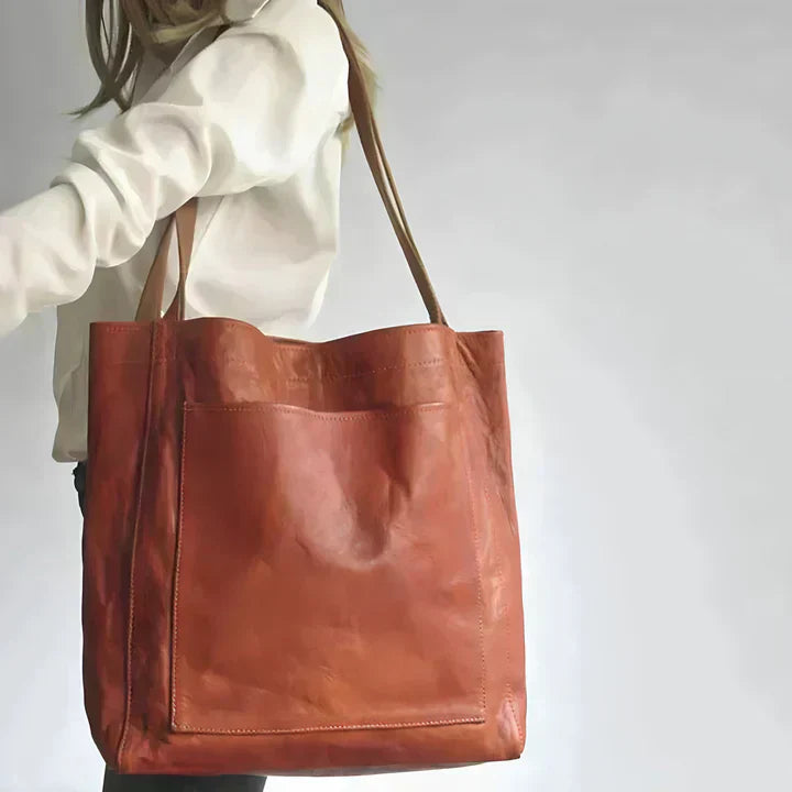 Elegant oversized women's grain leather tote bag, a sophisticated handbag with a distinct large external pocket.