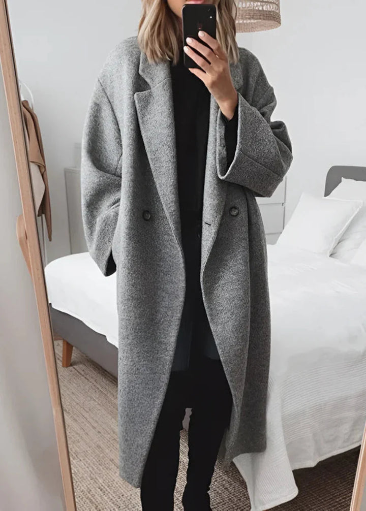 Model wearing a women's oversized maxi winter coat. Elegant longline outerwear providing luxurious warmth and chic style.