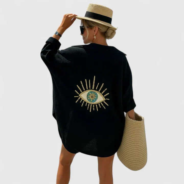 White long sleeve oversized beach shirt for women, featuring intricate evil eye embroidery. Versatile summer fashion statement top.
