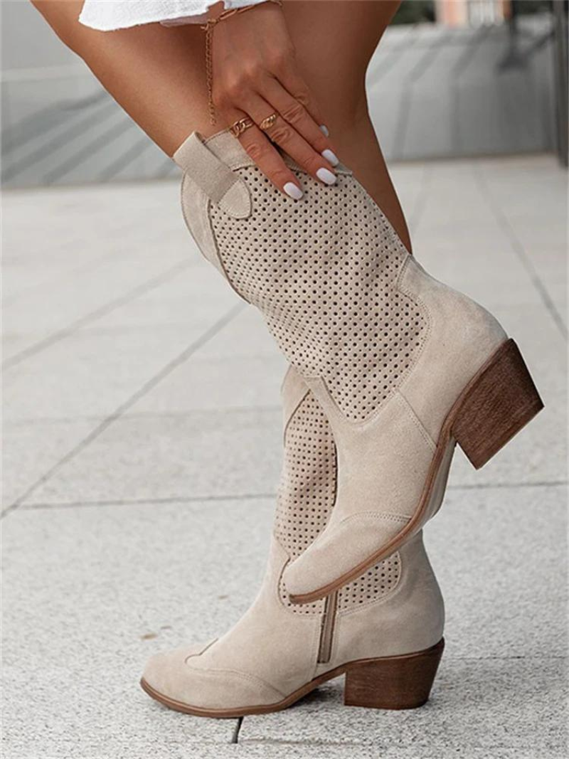 Close-up of women's perforated mid-calf western boots, showing detailed cutouts & pointed toe design.