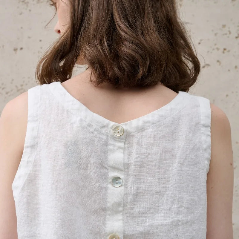 Modern minimalist pink sleeveless crop top for women, featuring an asymmetric hem and crew neck.