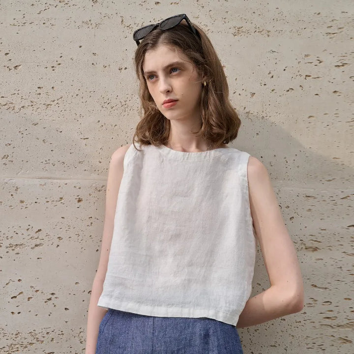 Relaxed fit white women's asymmetric crop top with a sleeveless cut and classic crew neck.