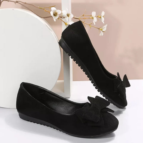 Women's pink ballet flats with a delicate bow accent, perfect for spring casual wear or elegant everyday outfits.
