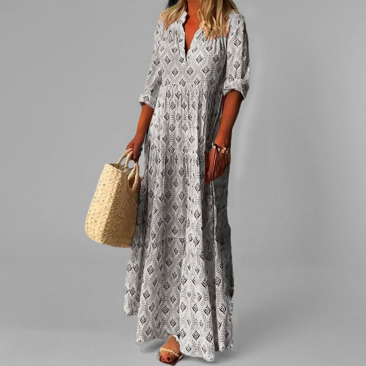 Grey women's tiered maxi dress, featuring a flattering V-neck & long sleeves. Versatile for modest casual or elegant looks.