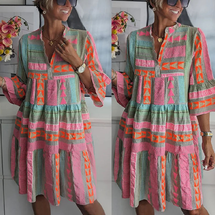 Vibrant pink women's tiered mini dress with a geometric print, ideal for a chic spring or day outfit.