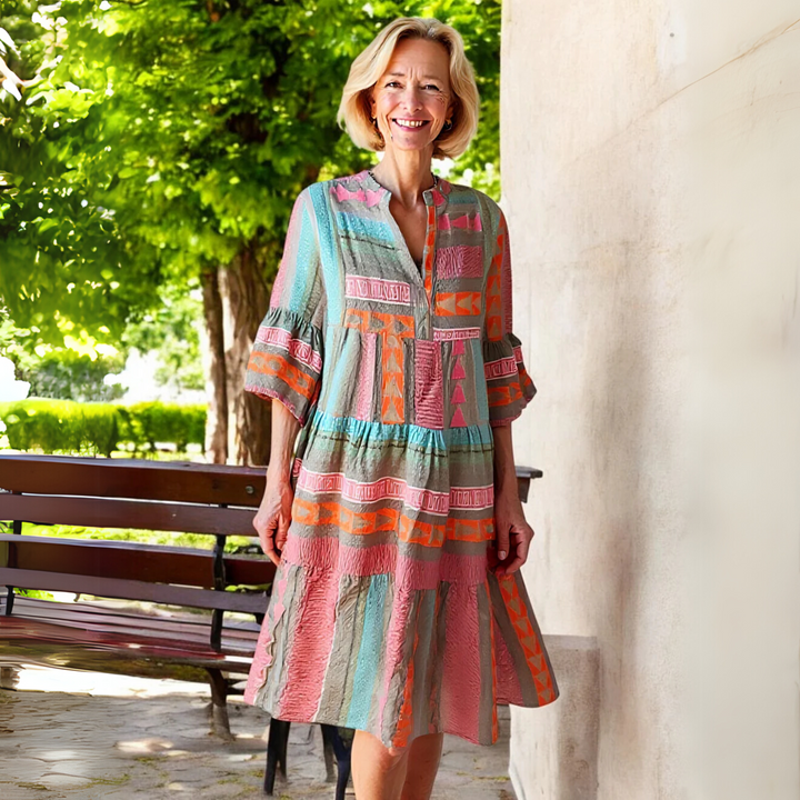 Women's pink tiered spring mini dress, showcasing a V-neck, 3/4 sleeves, and a fun geometric pattern.