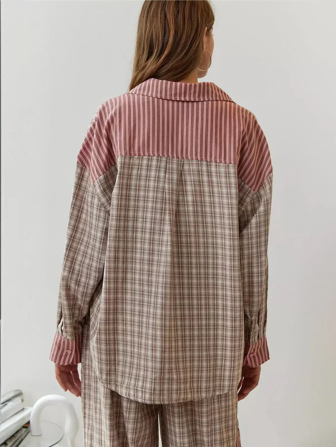 Stylish women's 2-piece plaid pajama set. Features a button-up long-sleeve top and comfy relaxed fit pants.