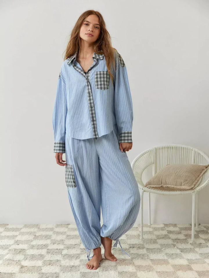 Two-piece women's plaid pajama set. Features a button-up long-sleeve top and matching relaxed fit sleepwear pants.