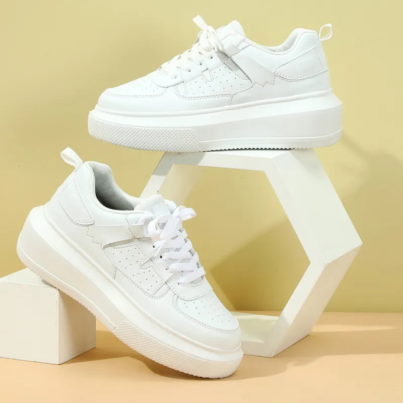 Women's platform sneakers with white upper, perforated detail, and classic lace-up design for casual wear.
