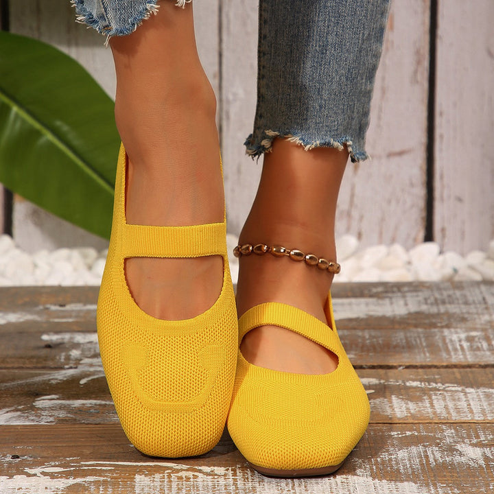 Stylish women's Mary Jane ballet flats with a playful smiling face design, adjustable strap & slip-on comfort.