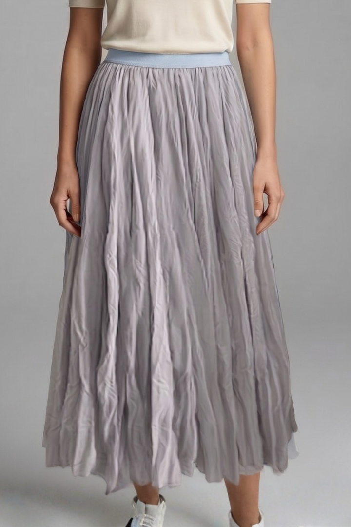 Modern women's maxi skirt, pleated for movement, features a practical elastic waist and long flowy design.