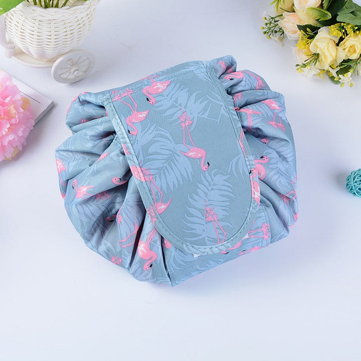 Woman holding open portable drawstring makeup bag, convenient access to women's travel essentials.