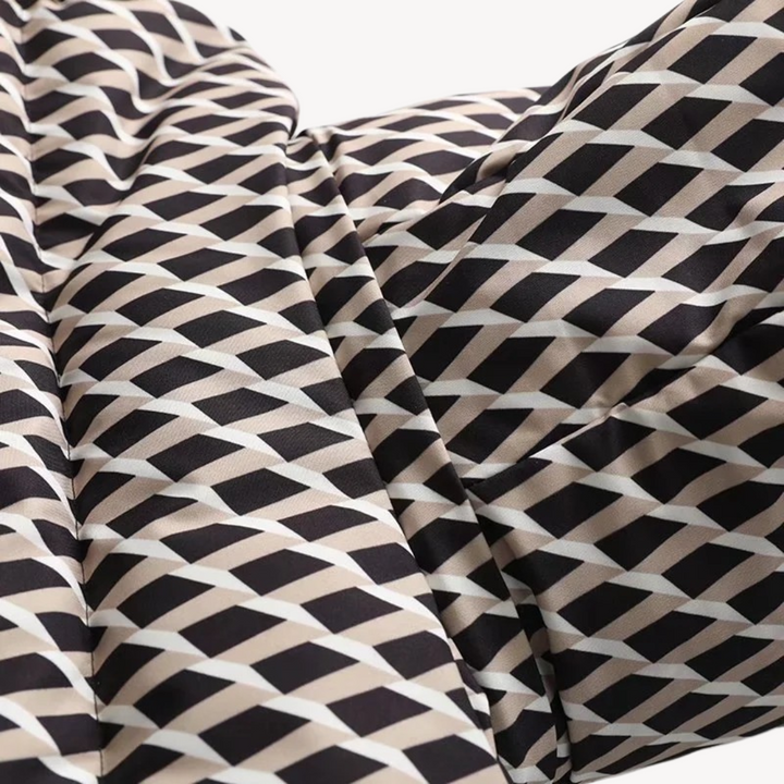 Full-body shot of a woman wearing a black quilted winter jacket with a belt and hood