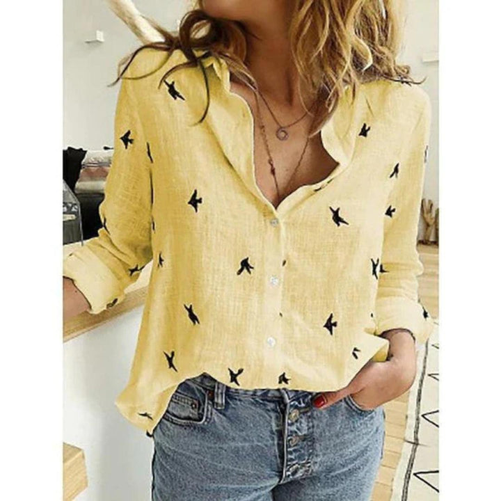 Comfortable women's relaxed fit blouse with unique bird print, classic button-down design.