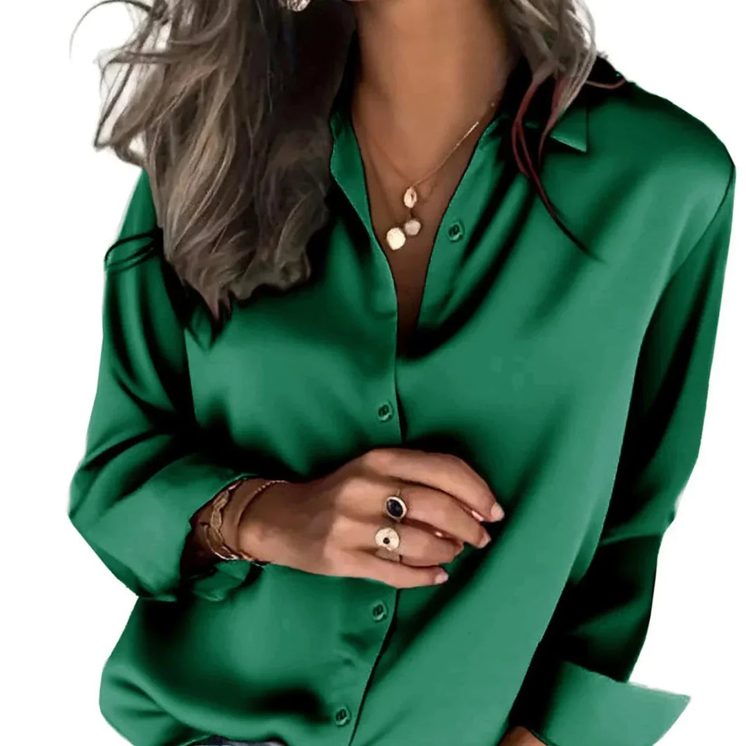 Woman wearing elegant blue relaxed button-down work shirt, long sleeve, sophisticated office wear.