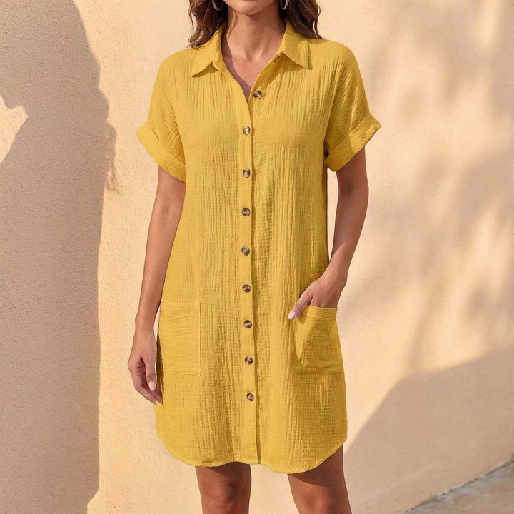 Detail shot: Button-front closure, collared neckline, & cuffed sleeves on a women's relaxed fit midi shirt dress.