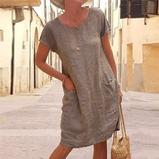 Everyday women's relaxed fit mini dress featuring practical pockets, short sleeves, and a comfortable round neck.