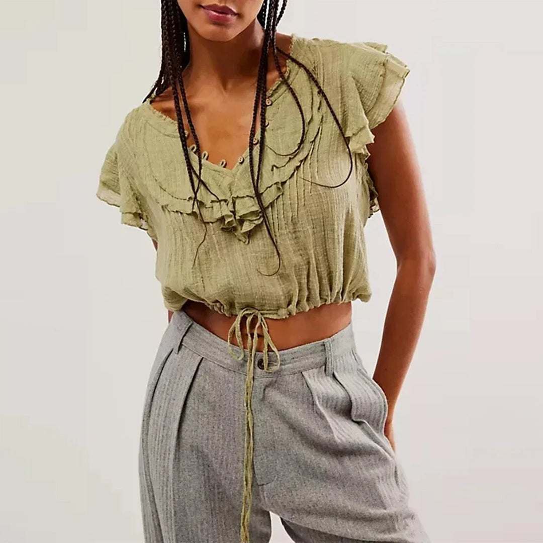 Effortless women's button-front crop top with flutter sleeves, great for beach and resort wear.