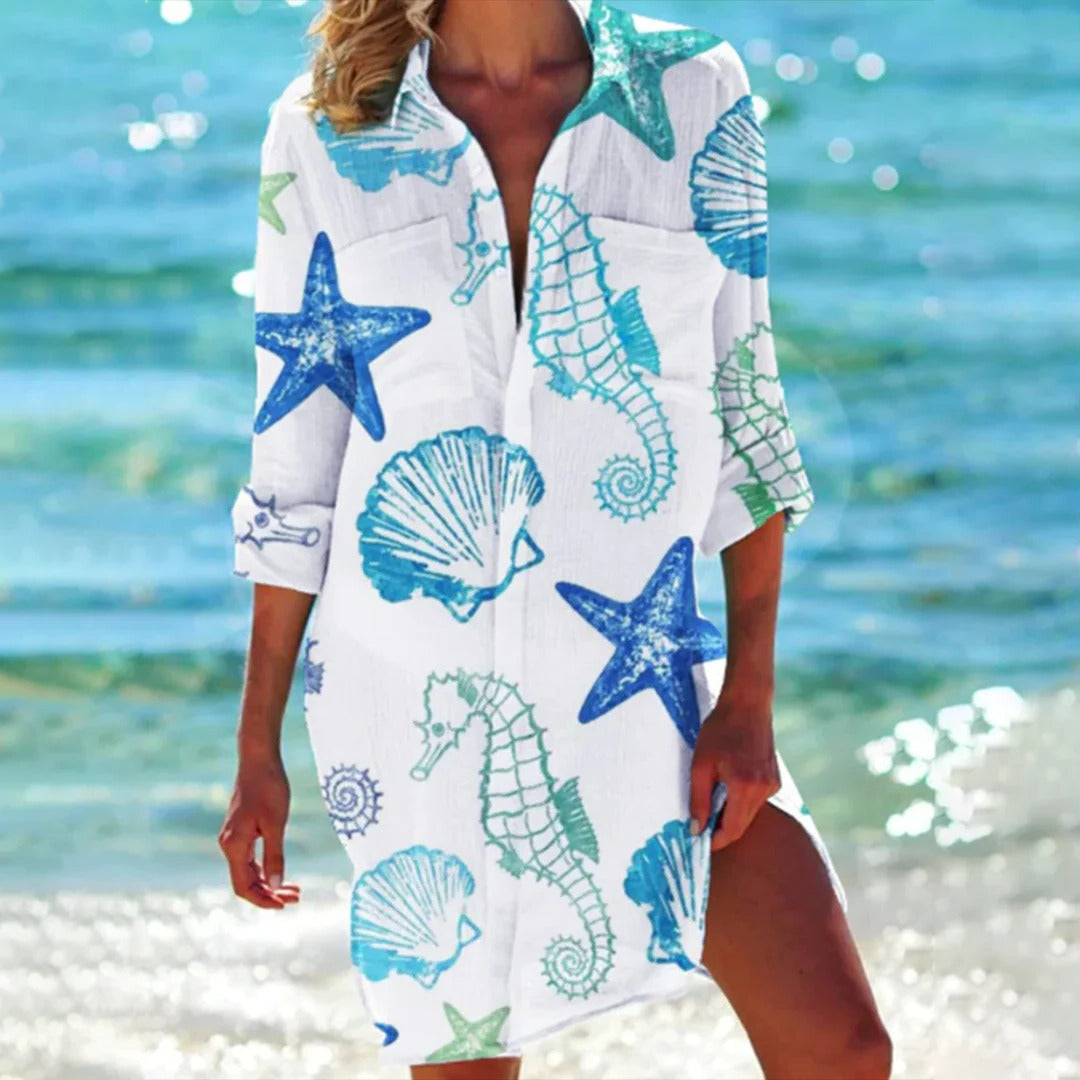 Women's long tunic shirt dress with a beautiful seashell print. 3/4 sleeves, a chic beach cover-up for resort wear.