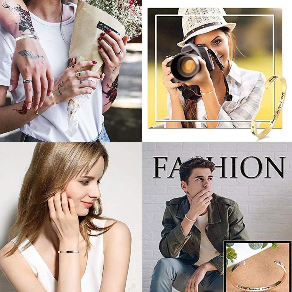 Stack of silver, gold, and black engraved stainless steel inspirational cuff bangles