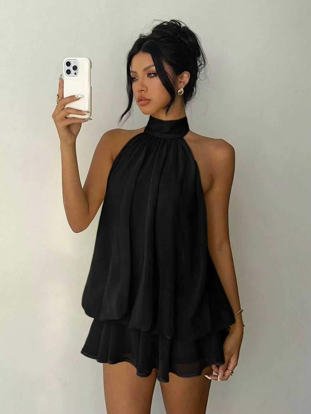 Front view of a chic women's sleeveless halter mini dress, showcasing a flattering cut & cute ruffle hem design.