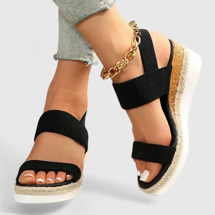 Comfortable women's espadrille wedge sandals featuring elastic straps, open toe, and jute sole. Easy slip-on.