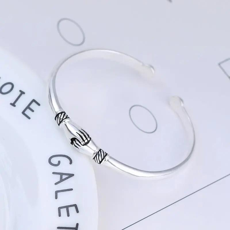 Side view of the sterling silver handshake bracelet, highlighting its sleek design