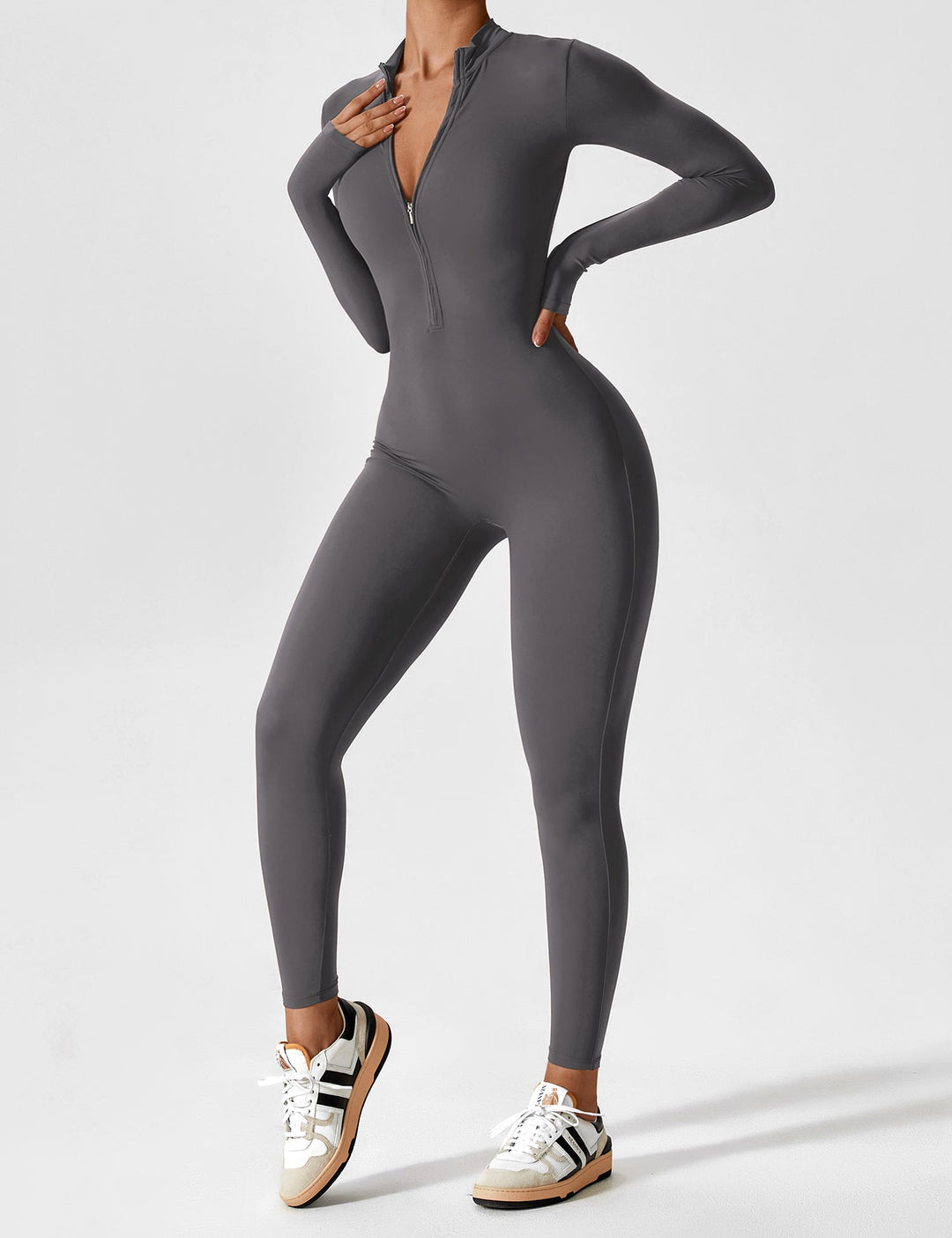 Woman sitting comfortably in a stretchy zip-up jumpsuit, showcasing its relaxed fit for spring