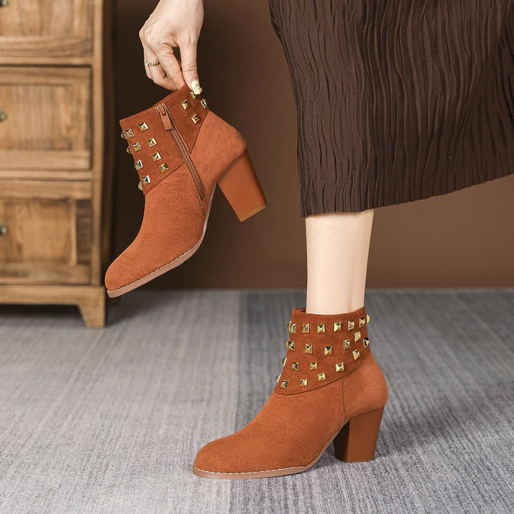 Close-up of the block heel on women's black studded ankle boots. Stable and fashionable design.