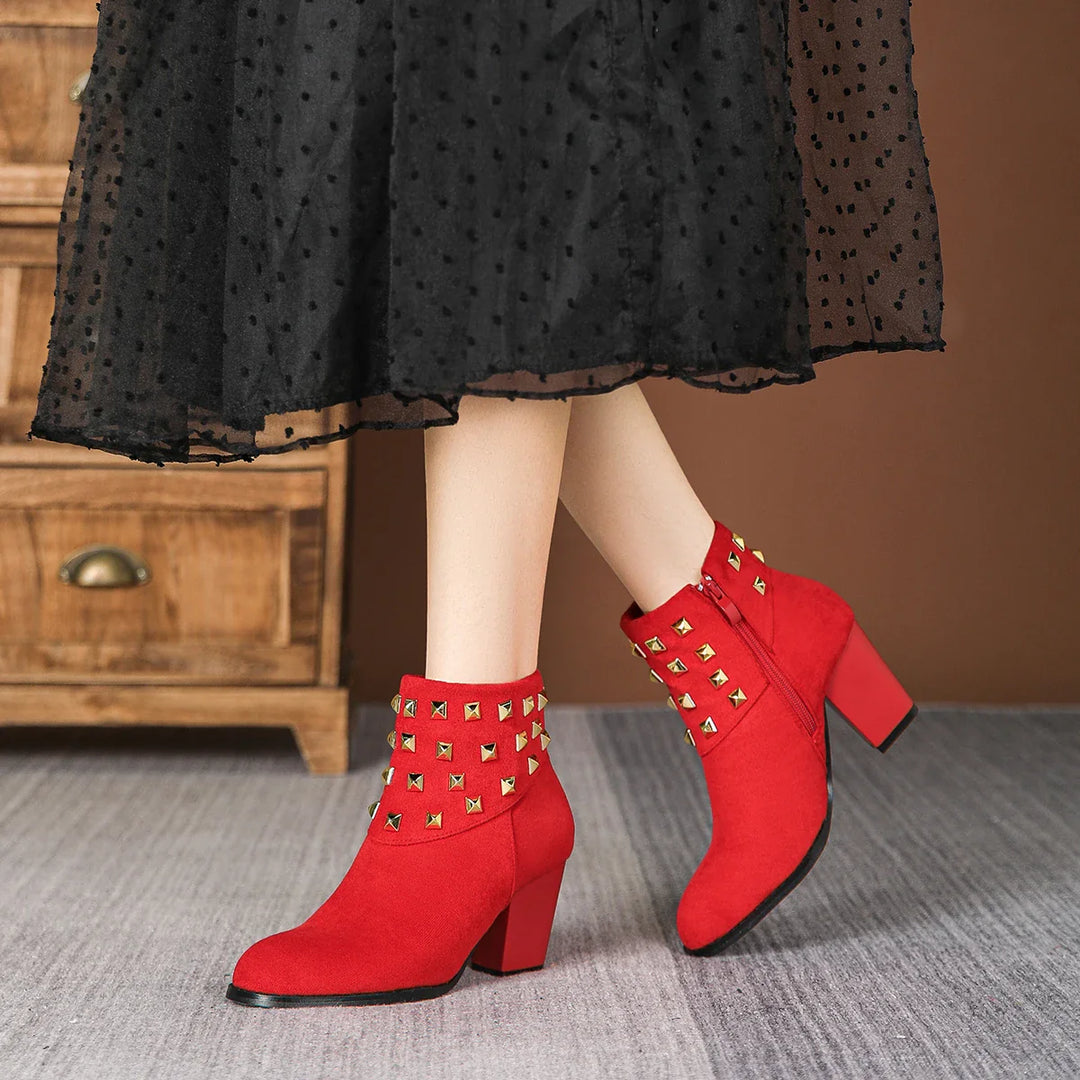 Woman wearing black studded ankle boots with jeans. Casual chic, fashionable women's footwear.