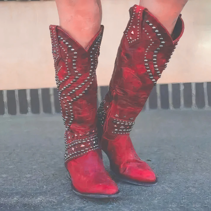 Fashionable women's knee-high western boots with studs, embodying classic cowboy style with a modern edge.