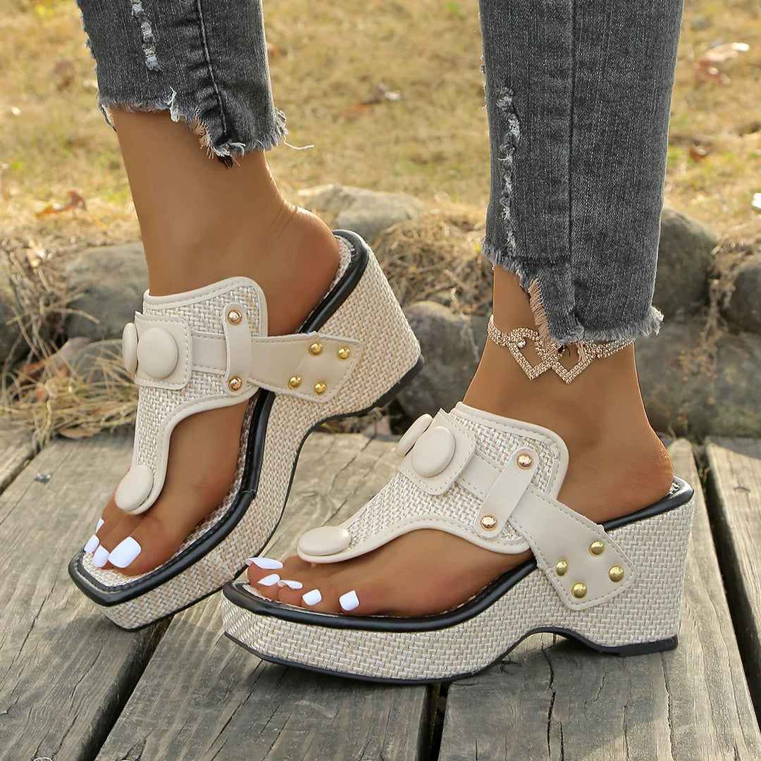 Pair of women's black studded platform wedge slides from above, summer sandals