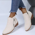 Detail of the durable zipper on women's elegant burgundy ankle boots, everyday wear