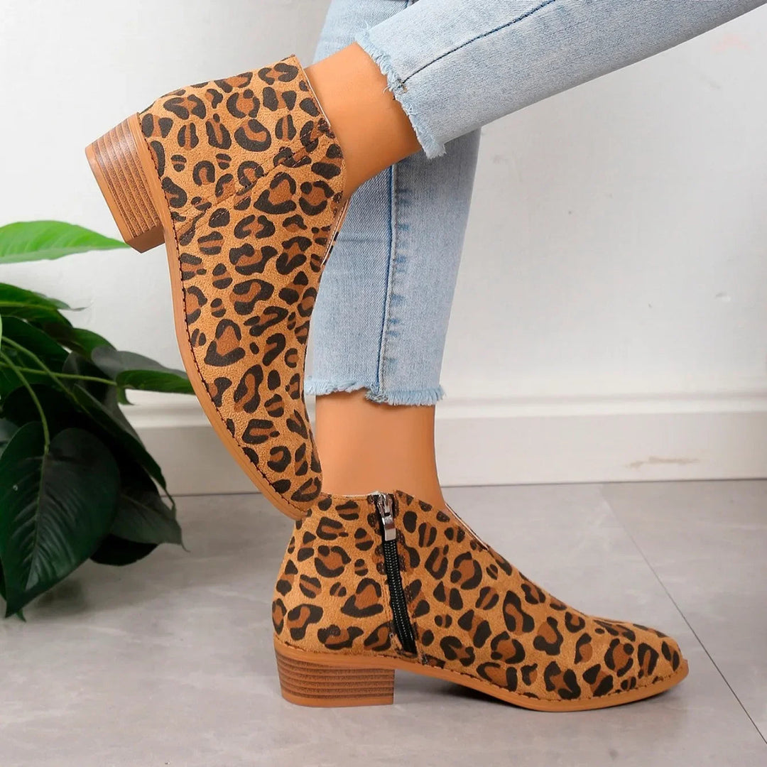 Close-up of women's leopard print ankle boots, highlighting the animal print texture and black zipper detail.