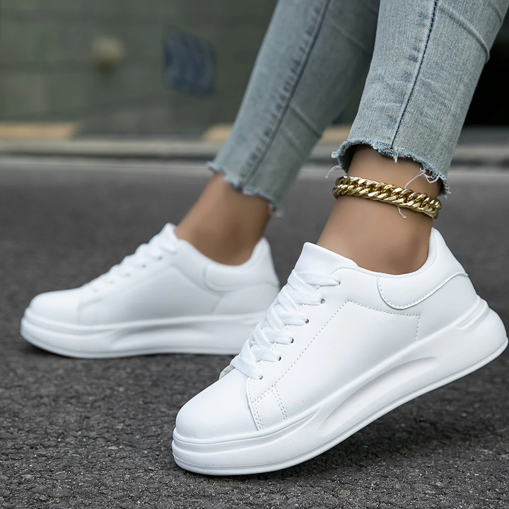 Fashionable women's black and white platform sneakers with lace-up closure for a modern, comfortable style.