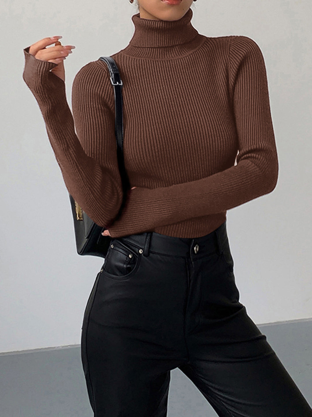 Model smiling while wearing a comfortable pink ribbed turtleneck pullover, showcasing its relaxed fit.