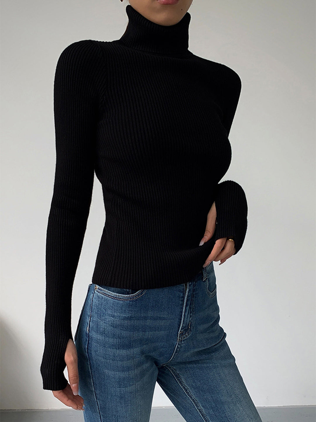 Front view of a white women's ribbed turtleneck, a classic and sophisticated knit top.