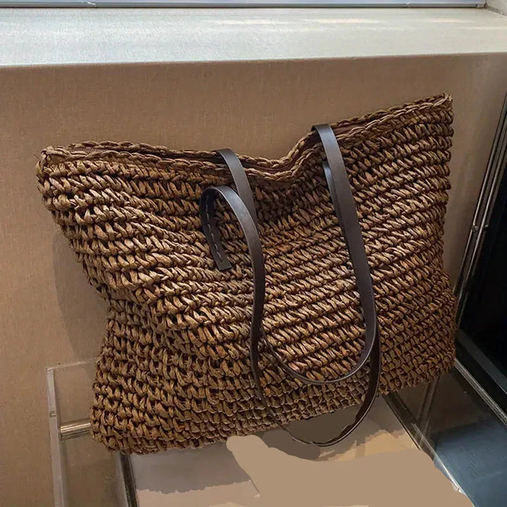 Close-up of a women's stylish woven straw tote bag, showcasing texture for beach/summer.