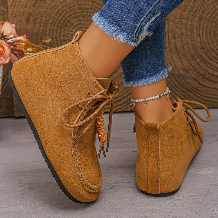 Woman wearing suede lace-up ankle boots, showcasing casual and comfortable style