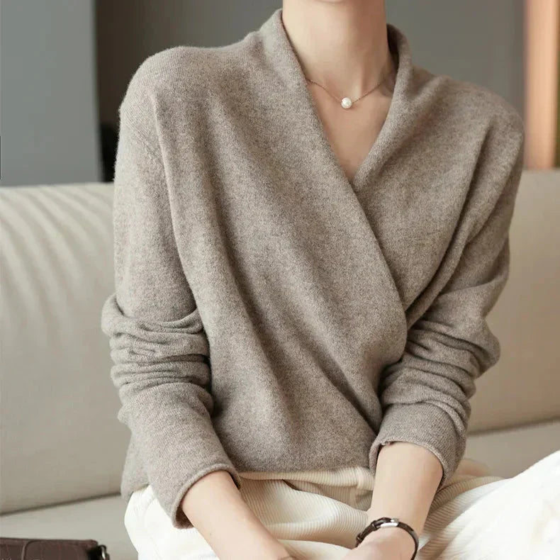 Back view of a women's long sleeve knit wrap neck top, emphasizing its flowing silhouette.