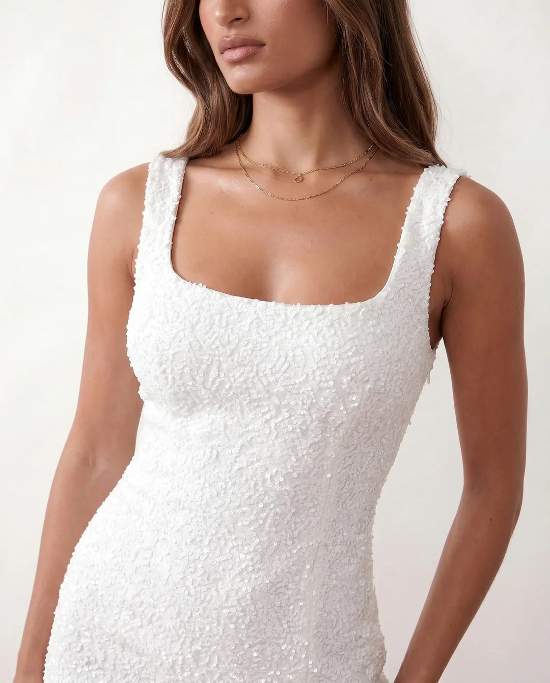 Glittering sleeveless homecoming mini dress with textured sequins, bodycon fit.