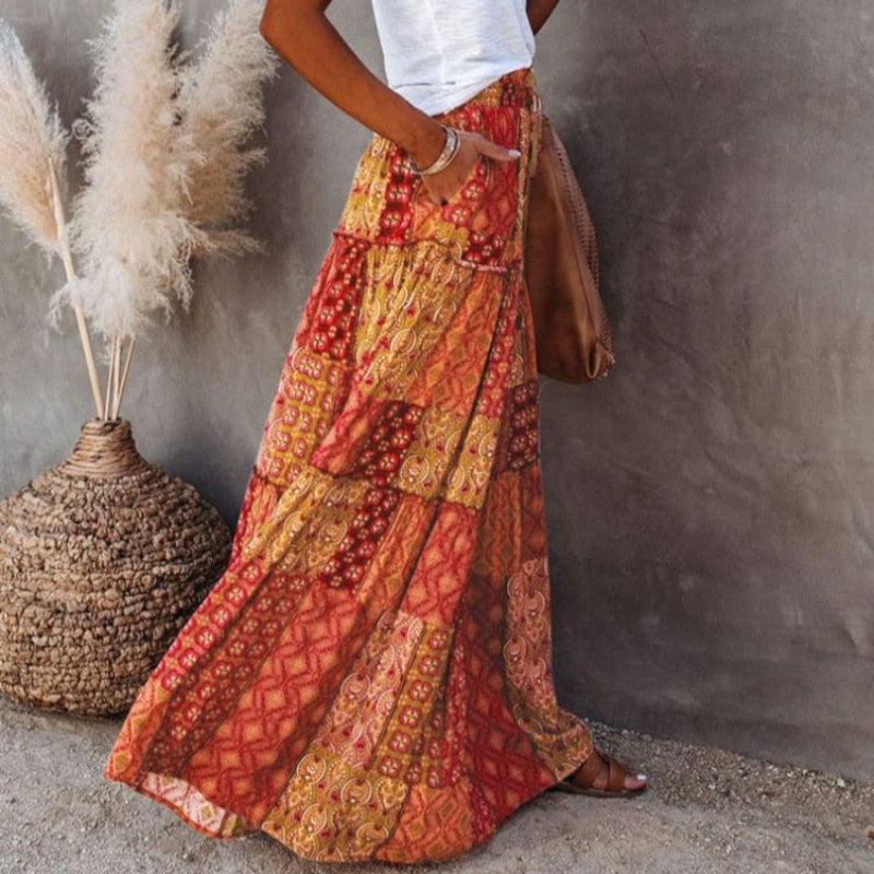 Bohemian flowy women's maxi skirt with tiers and floral pattern. High elastic waist for relaxed summer style.