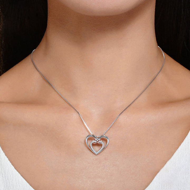 Close-up of Two Hearts Infinity Necklace, polished silver, sparkling delicate design