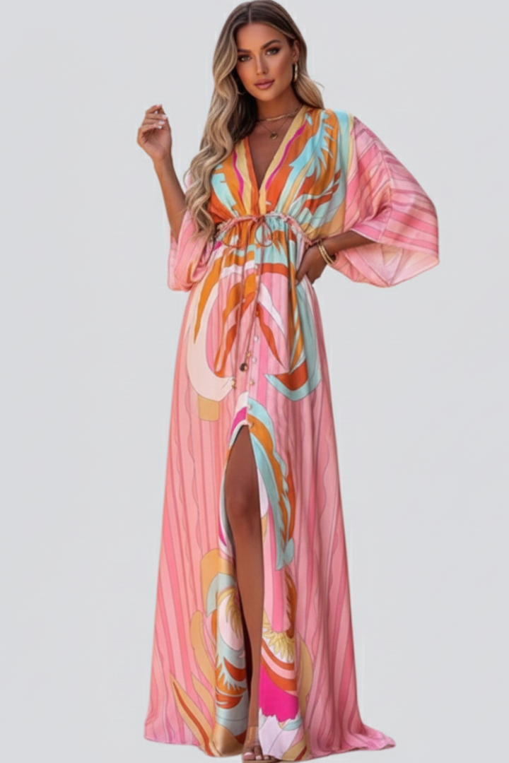 Flowing women's maxi dress in vibrant pink abstract print. Features a flattering V-neck and a cinching waist belt.