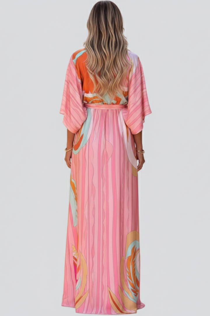 Chic women's pink abstract print maxi dress. Features a deep V-neck and a matching waist belt for a flowing summer look.