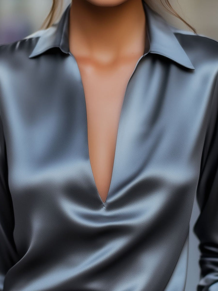 Close-up of a flowy women's V-neck satin blouse, highlighting the luxurious fabric and long sleeve detail.