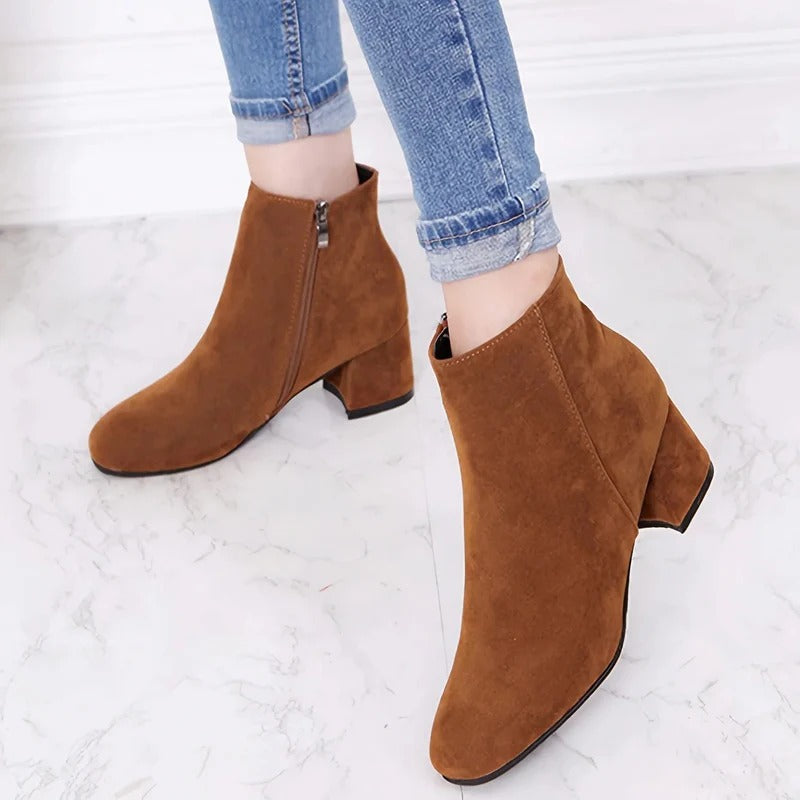 Black women's ankle boots with block heel & side zip, ideal for fall & winter fashion, comfortable everyday wear.