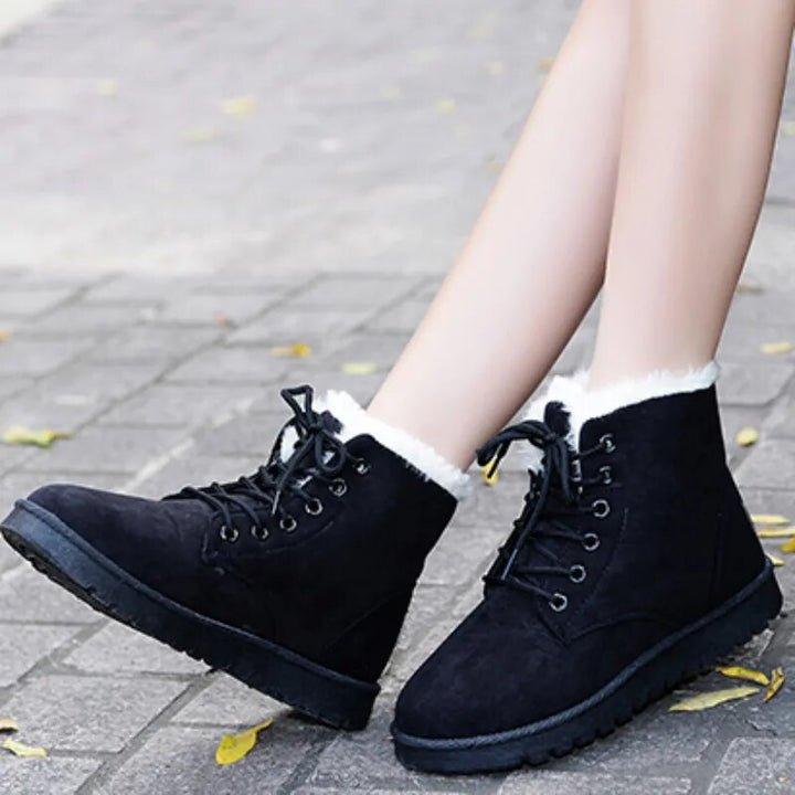Pair of tan women's winter ankle boots, lace-up style, designed for warmth and comfort.