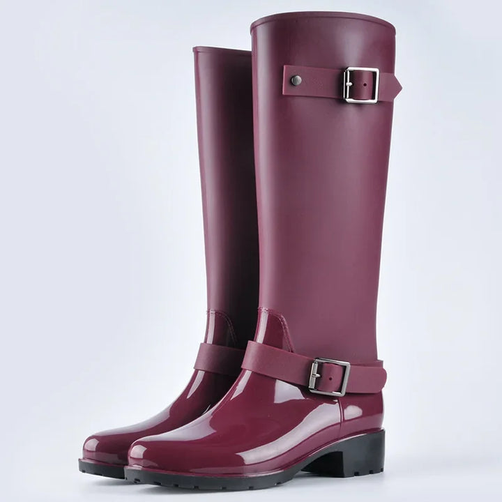 Modern women's knee-high waterproof rain boots with decorative buckles and comfortable block heels.