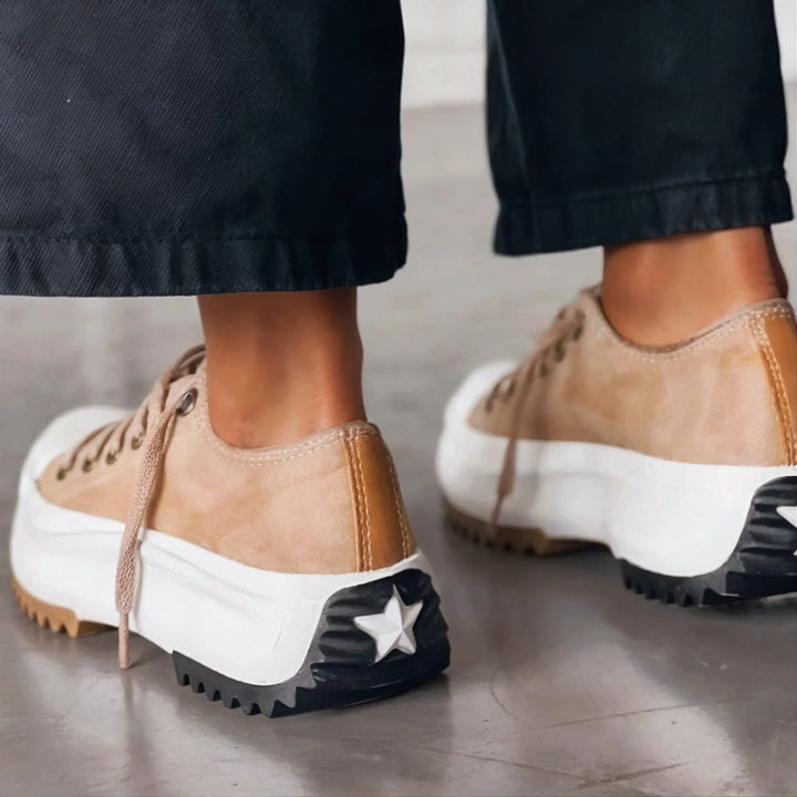White women's casual platform sneakers featuring a lace-up low-top design and an elevated sole for chic fashion.